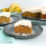 A piece of dairy free banana cake on a plate next to a napkin.