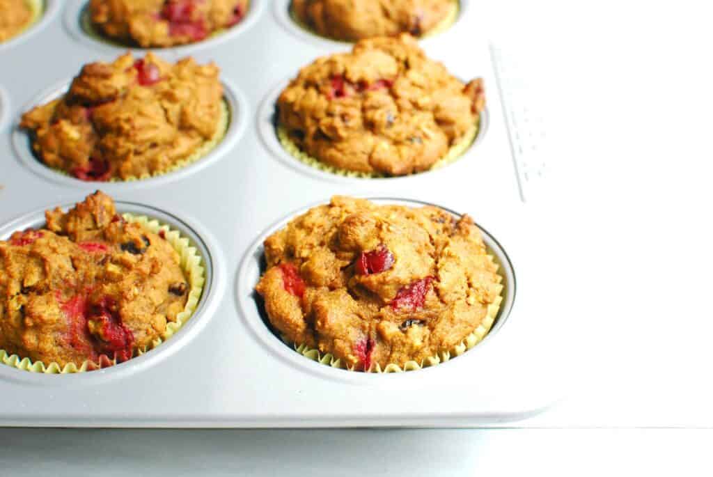 Just-baked pumpkin cranberry muffins in the muffin tin.