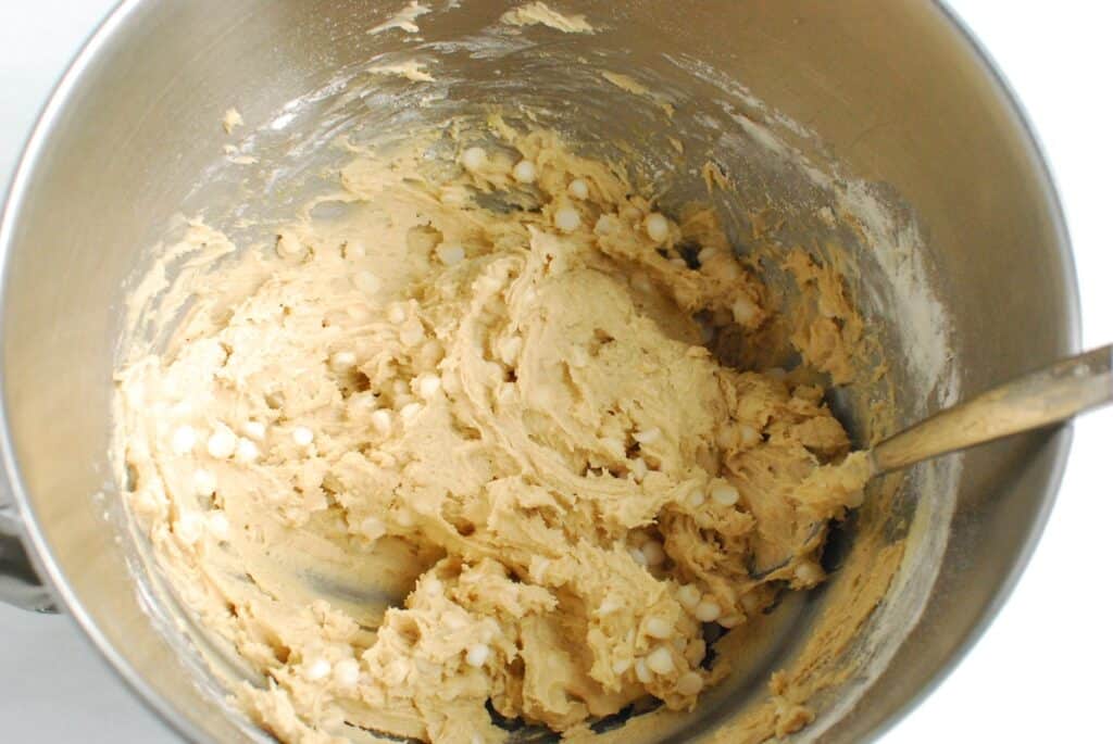 Cookie dough in a silver mixing bowl.