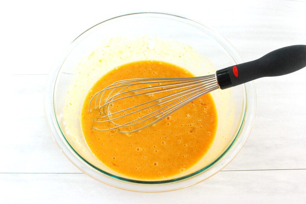Eggs, pumpkin, almond milk, salt, and pepper whisked together in a glass bowl.