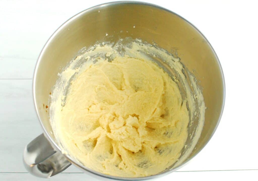 Dairy-free butter, sugar, egg, and vanilla mixed together in a silver bowl.