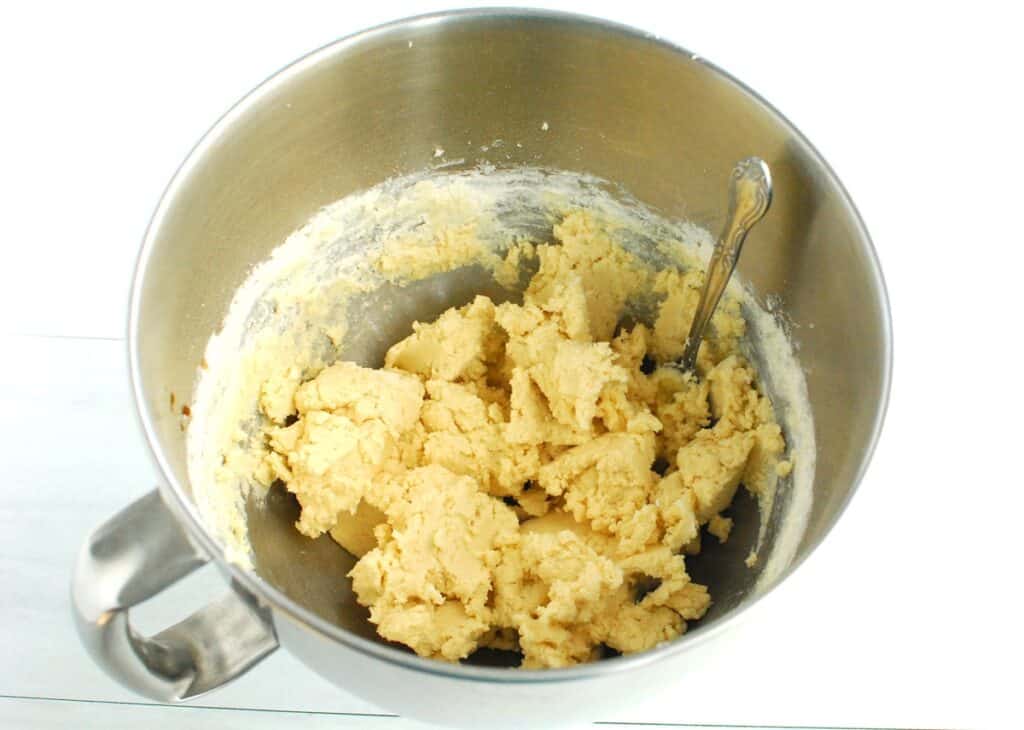 Cookie dough in a silver mixing bowl.