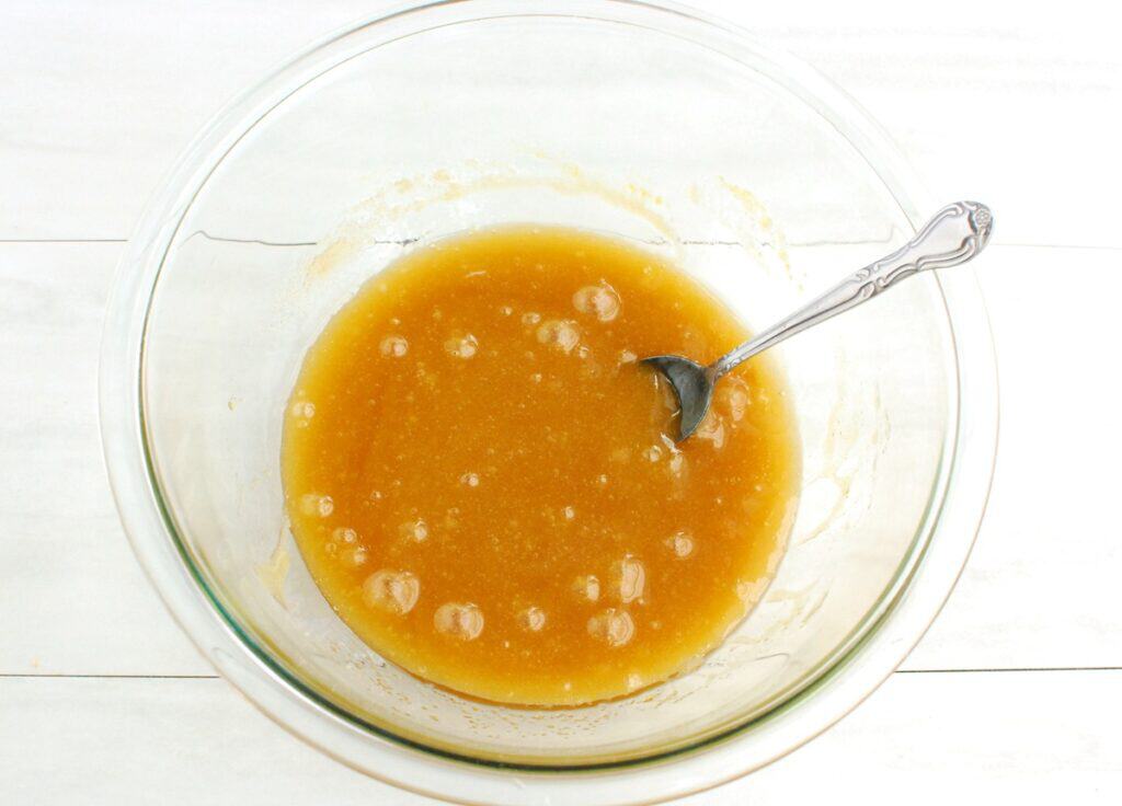 Brown sugar, egg, oil, and vanilla extract mixed together in a glass bowl.