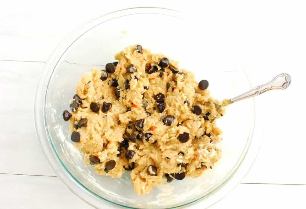 Cookie dough mixture in a glass mixing bowl.