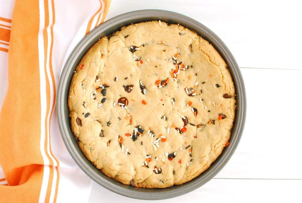 Just-baked cookie cake in a cake pan.
