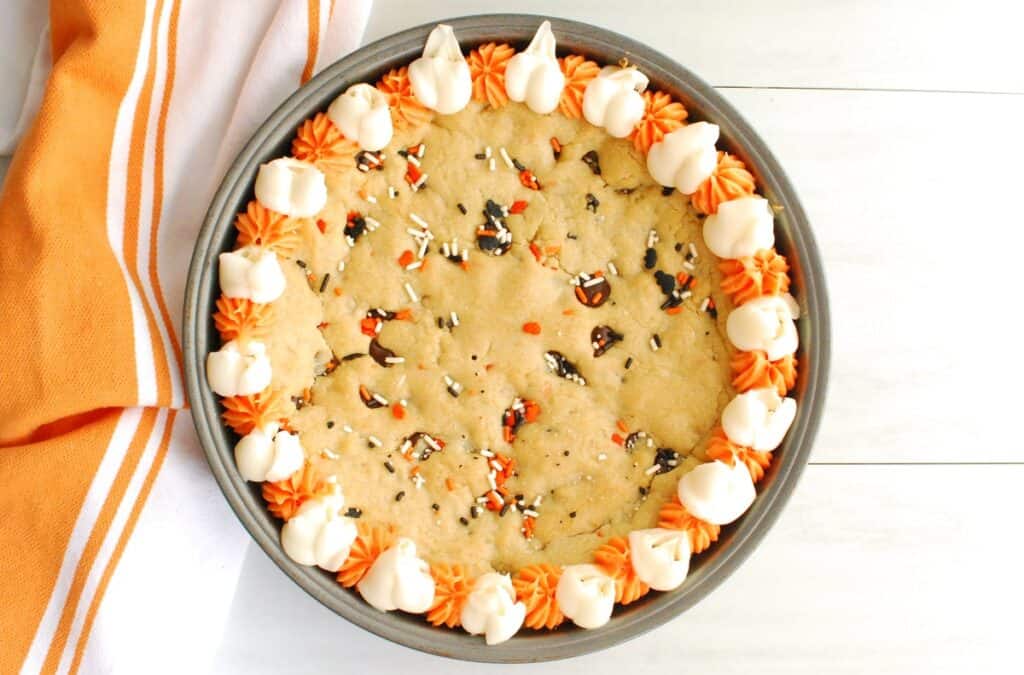A round cake pan filled with an oil-based Halloween cookie cake.
