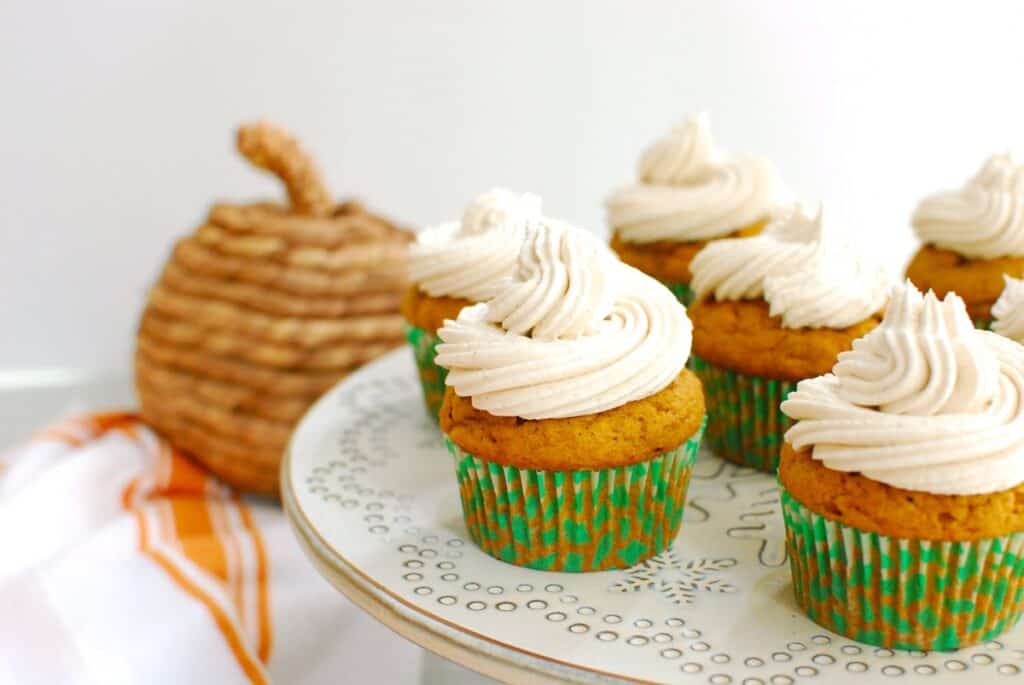 A dairy free pumpkin cupcake with swirled dairy-free cream cheese frosting.