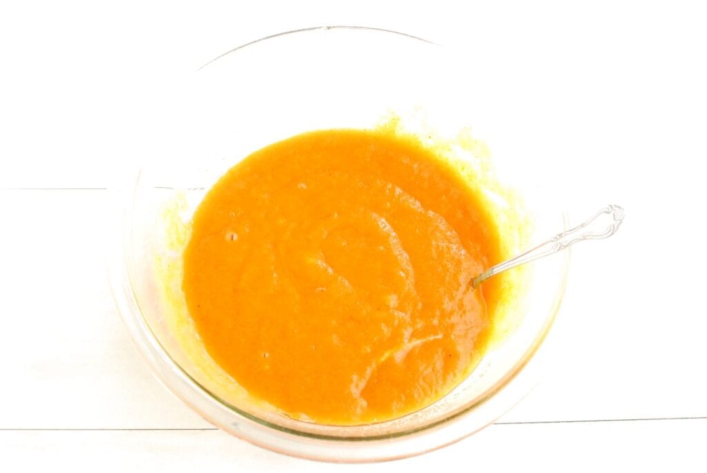 Pumpkin puree, oil, sugar, brown sugar, eggs, and vanilla mixed together in a bowl.