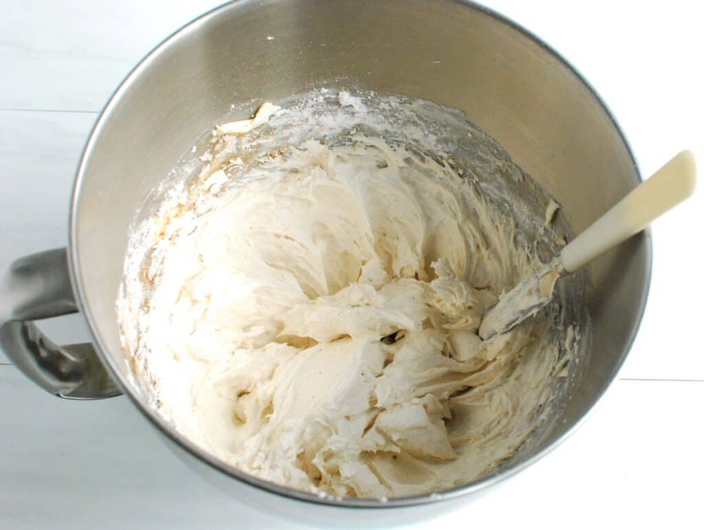 Frosting in a silver mixing bowl.