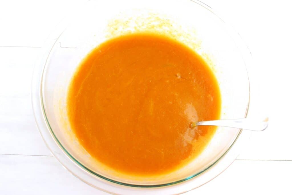 Pumpkin puree, sugar, brown sugar, vegetable oil, oat milk, and eggs mixed together in a large mixing bowl.