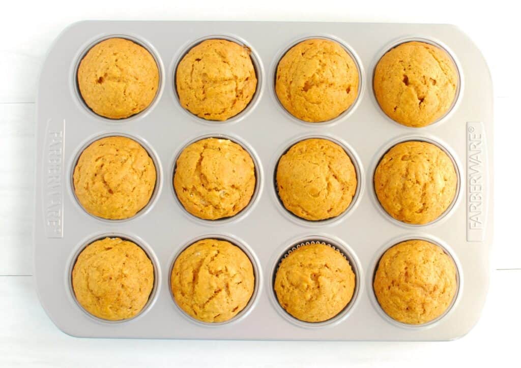 A muffin tin with just-bake pumpkin muffins.