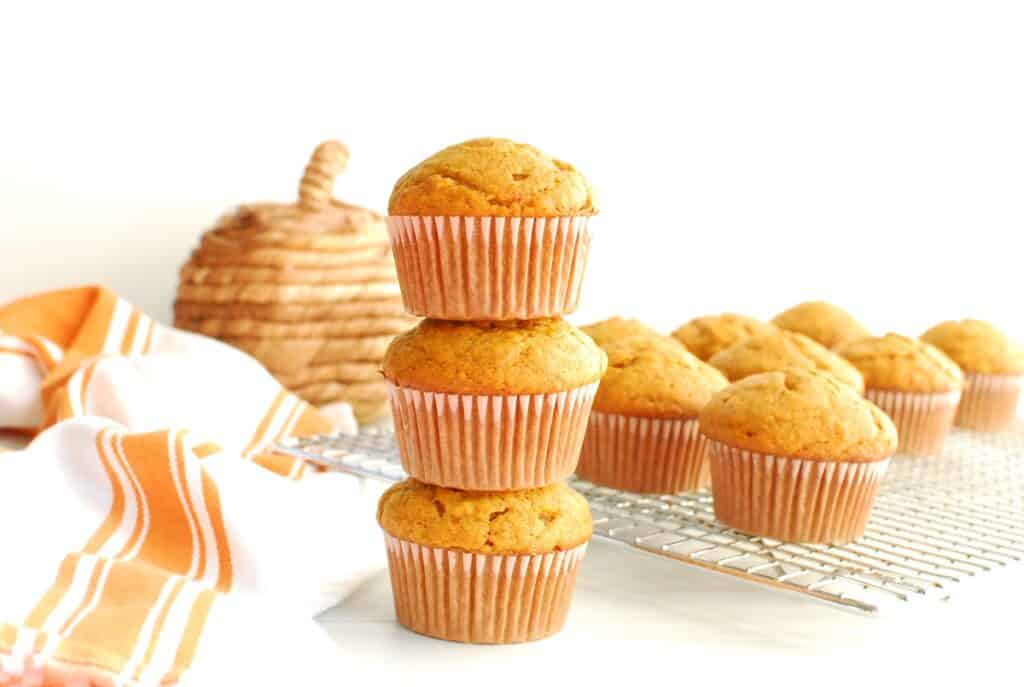 Three dairy free pumpkin muffins stacked on top of each other.
