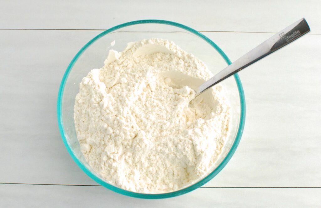 Flour, baking soda, and salt mixed together in a bowl.