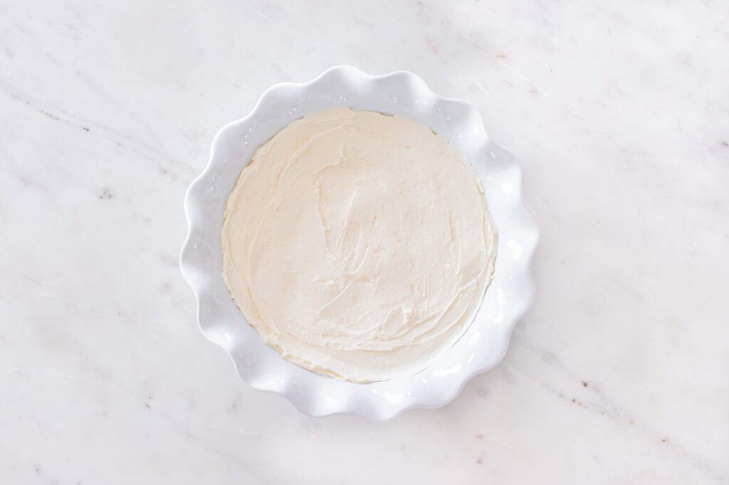 Cream cheese mixture spread into a pie plate.