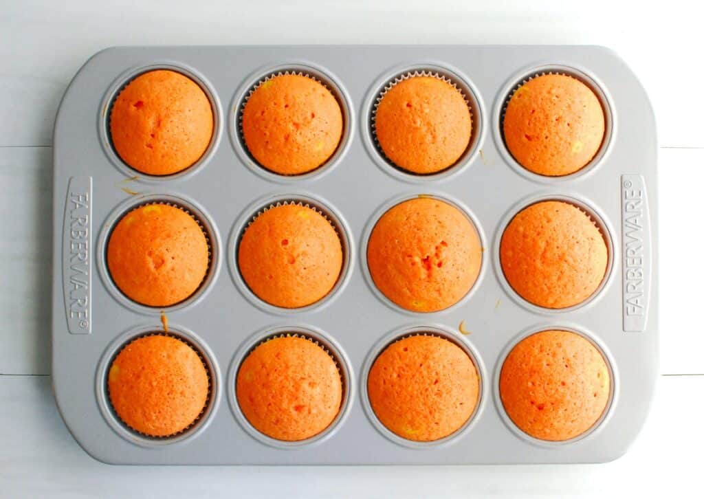 Just-baked cupcakes in a cupcake tin.