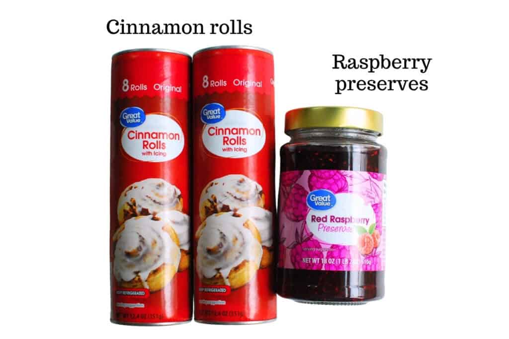 Two cans of refrigerated cinnamon rolls and a jar of raspberry preserves.