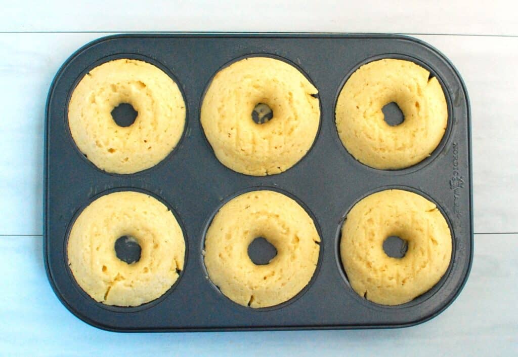 Just-baked donuts in a donut pan.