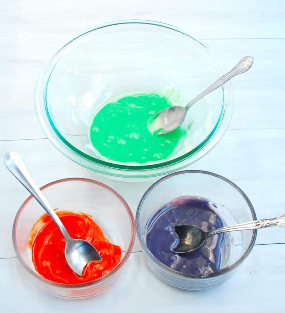 Icing divided into bowls and made into Halloween colors with food coloring.