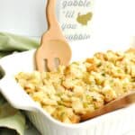 A casserole dish with dairy free stuffing and wooden spoons to scoop it out.