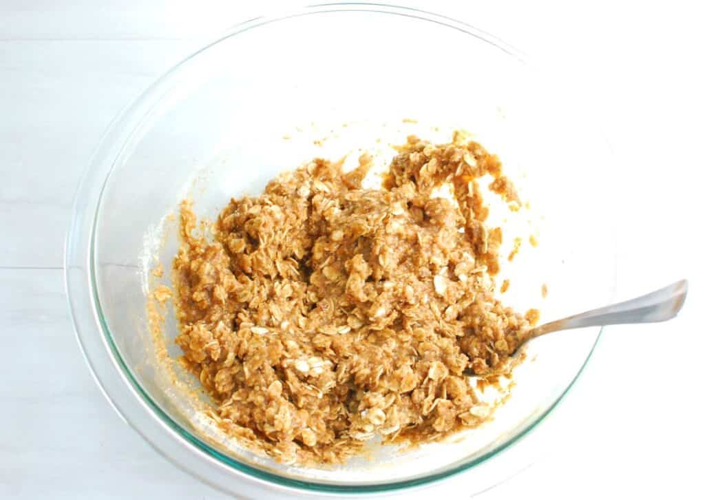 Oats, almond flour, and salt added to the wet ingredients in the mixing bowl.