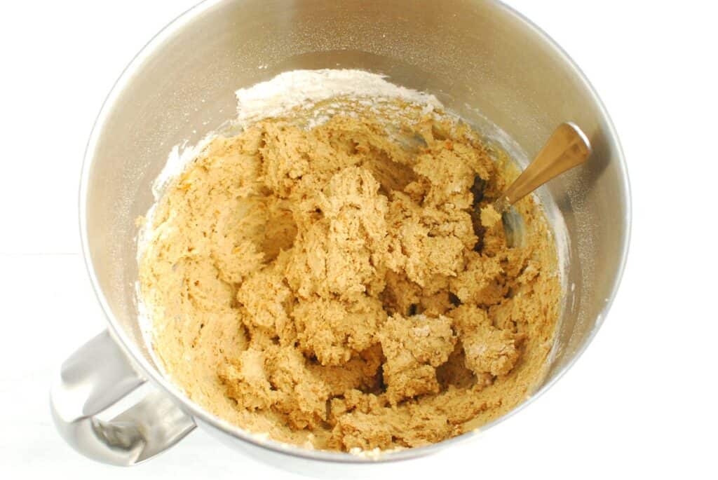 Cookie dough in a silver mixing bowl.