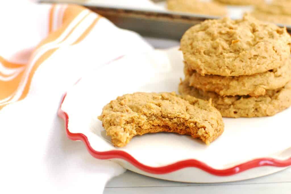 A butternut squash cookie on a plate with a bite taken out of it.
