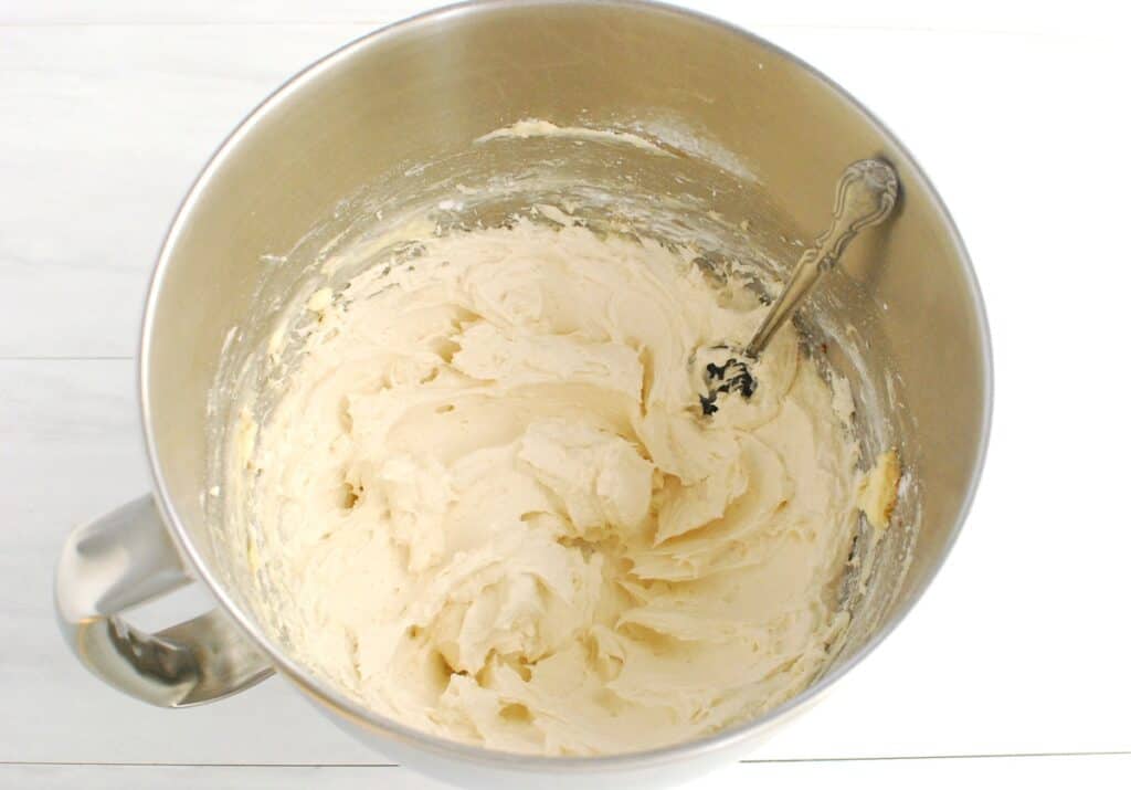 Dairy-free cream cheese frosting in a silver mixing bowl.
