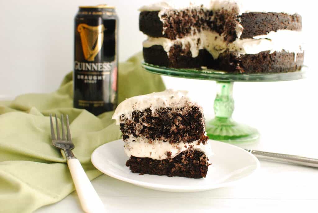 A slice of Guinness chocolate cake on a plate next to a fork and napkin.