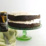 A two-layer dairy free Guinness chocolate cake on a cake stand.