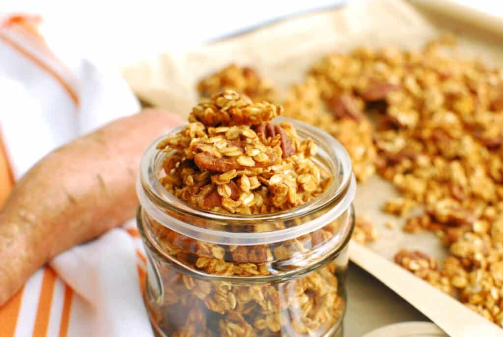 Sweet potato granola spilling over the top of a jar.