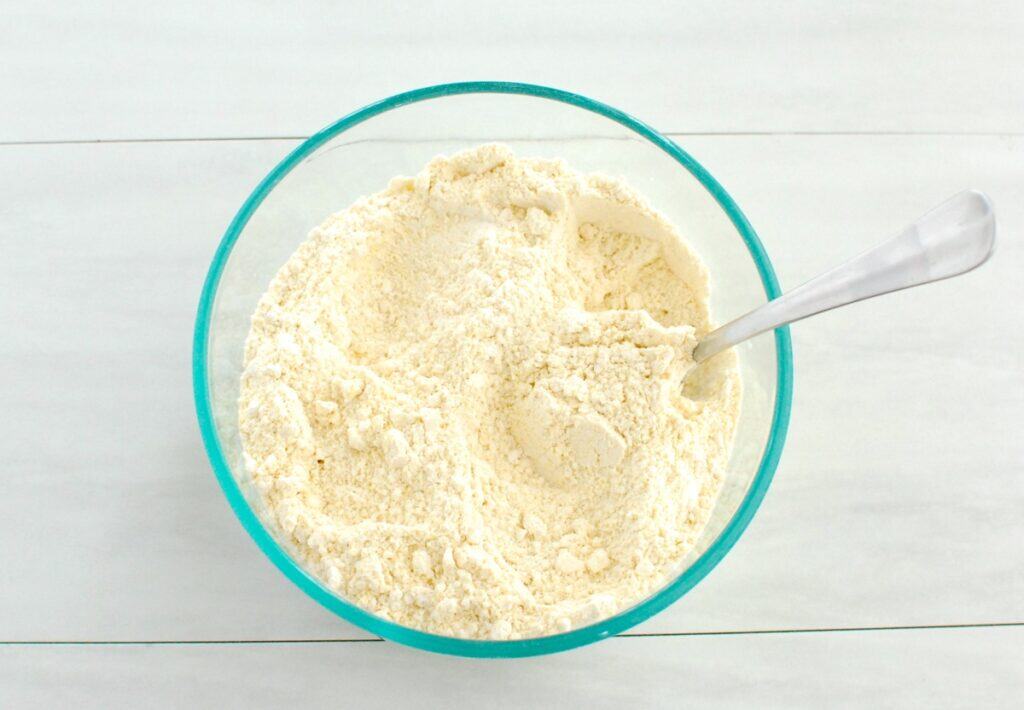 Flour, cornmeal, baking soda, and salt mixed together in a bowl.