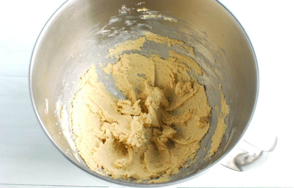 Butter, sugar, and brown sugar creamed together in a mixing bowl.