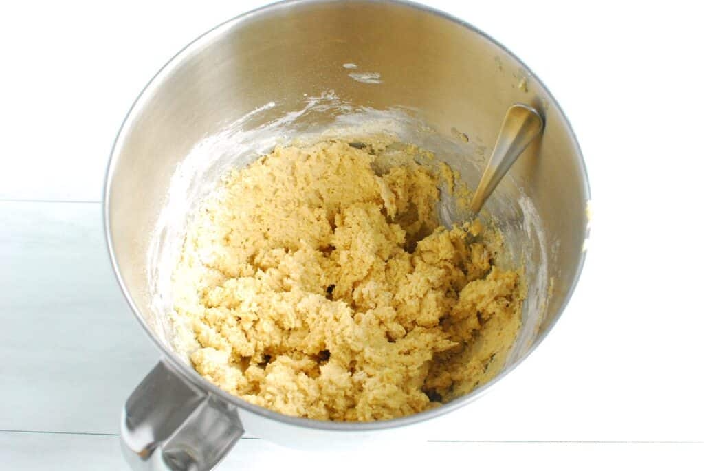 Cookie dough in a silver mixing bowl.