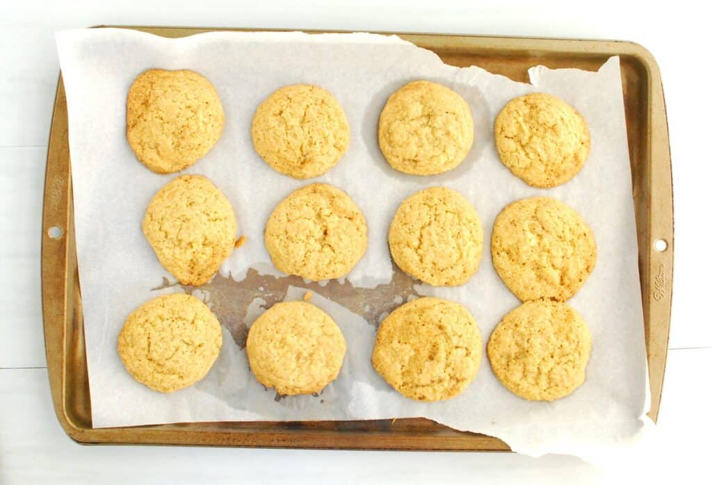 Just-baked cookies on a parchment-lined baking sheet.