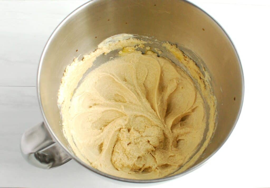 Egg and vanilla mixed into the bowl with the dairy-free butter and sugar.