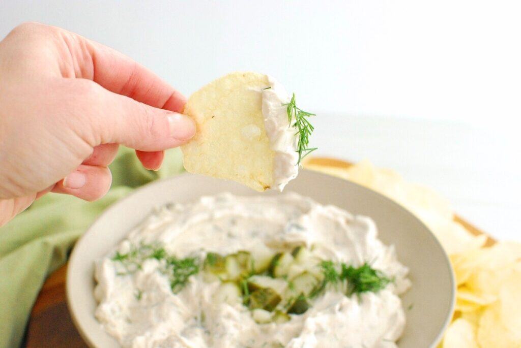 A potato chip dipped in pickle dip.