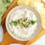 A bowl of dairy free pickle dip garnished with dill and chopped pickles.