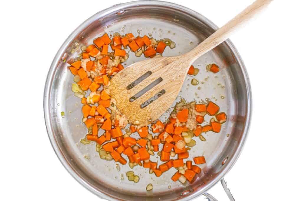 Carrots, onions, garlic, and ginger in a sauté pan.