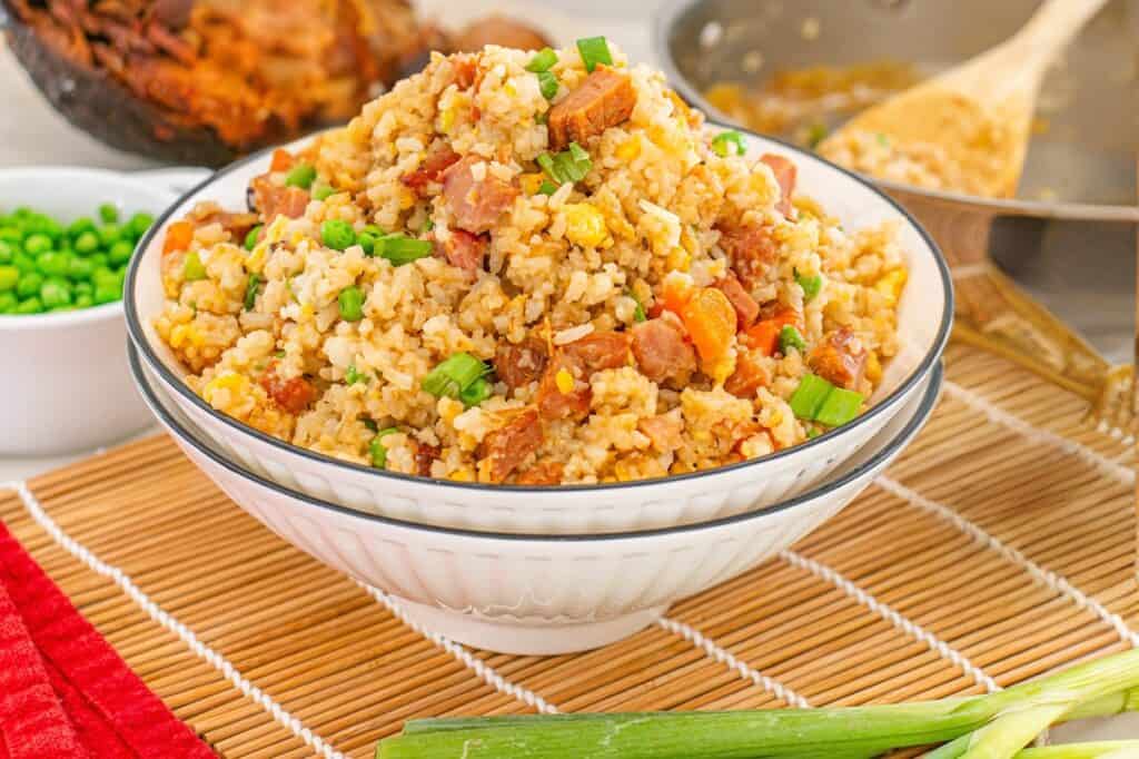 A bowl of ham fried rice on a placemat.