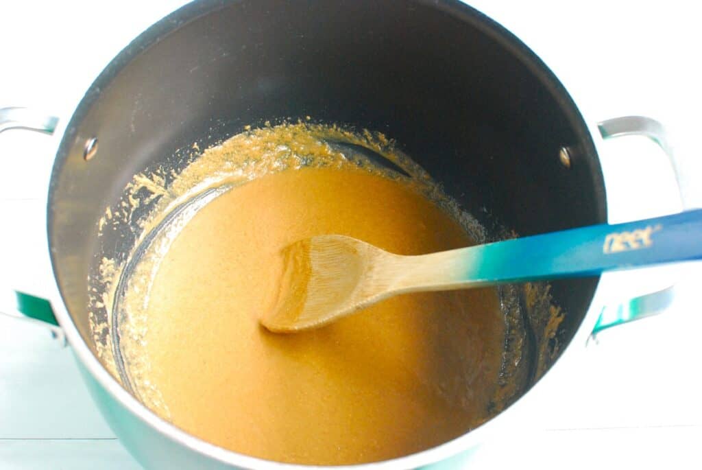 Honey, coconut oil, and peanut butter mixed together in a pot.