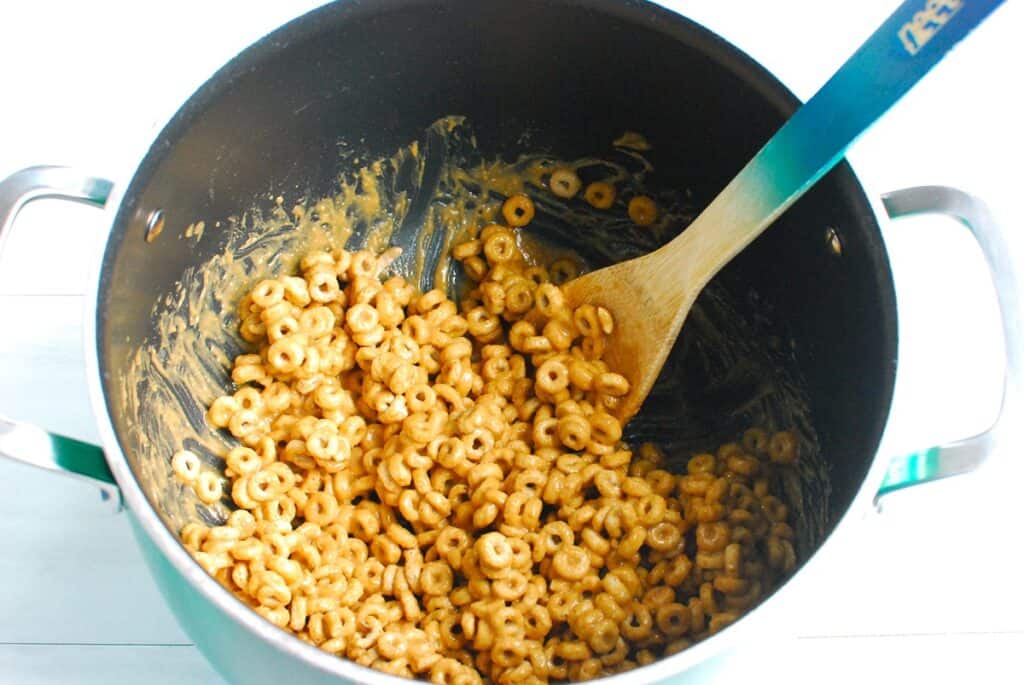 Cheerios added to the pot and mixed with the peanut butter honey mixture.
