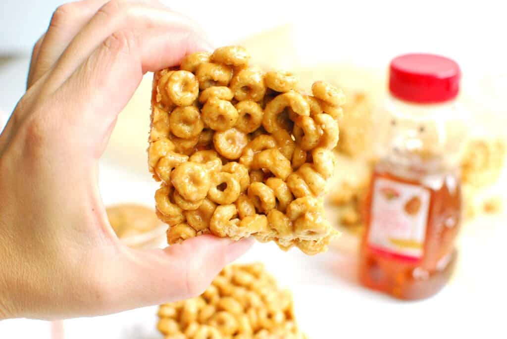 A woman's hand holding a cheerio bar.