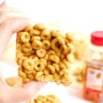 A hand holding a peanut butter honey cheerios treat.