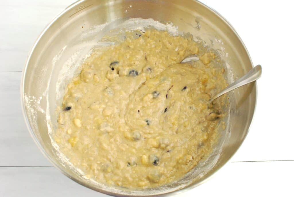 Muffin batter in a silver mixing bowl.
