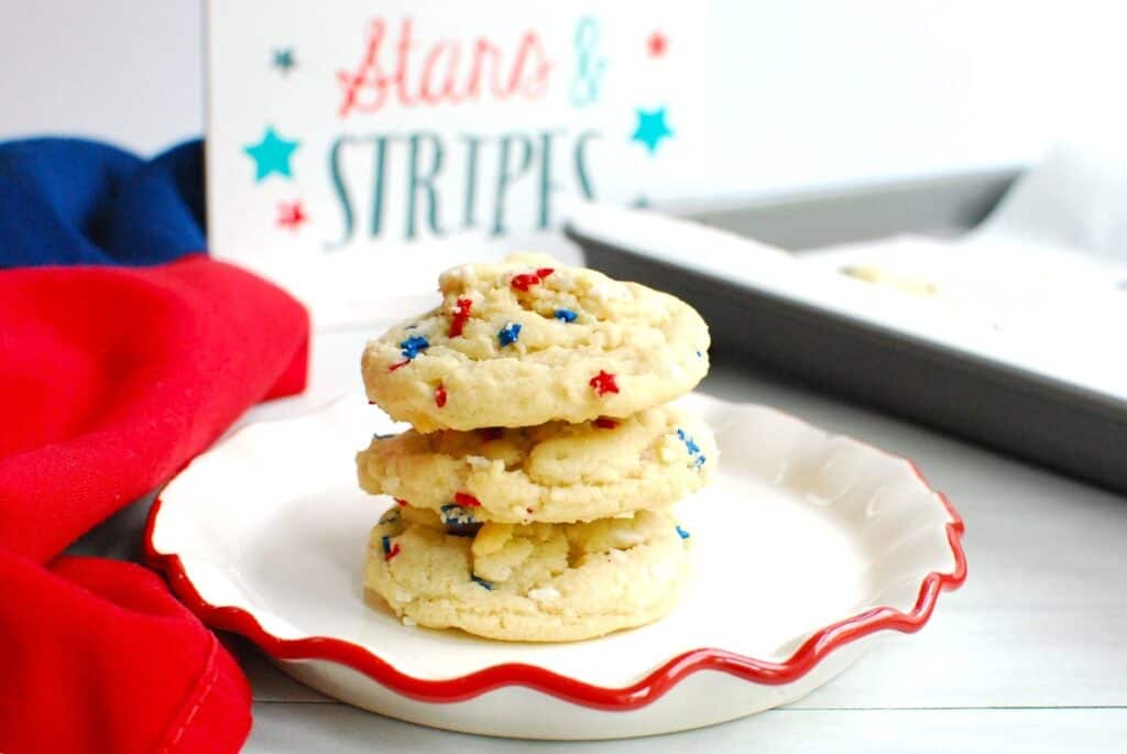 Three coconut oil sugar cookies stacked on a plate.