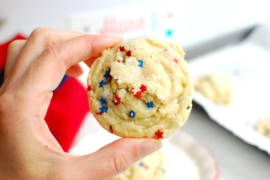 A woman's hand holding a coconut oil sugar cookie.