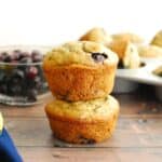 Two dairy free banana blueberry muffins stacked on top of each other.