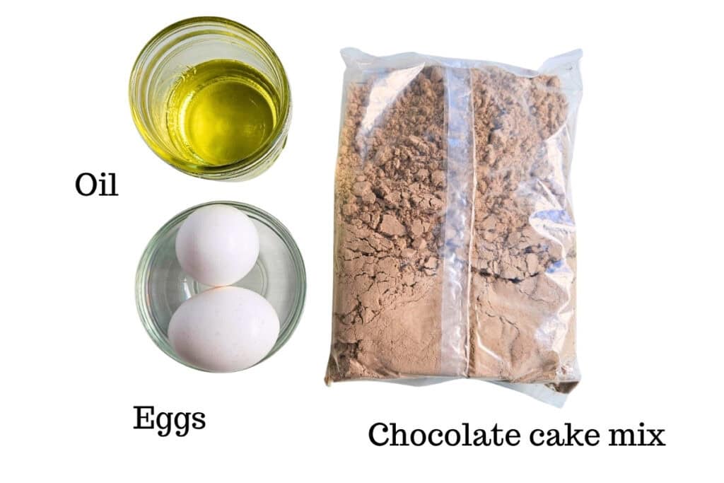 Chocolate cake mix, eggs, and oil on a white backdrop.
