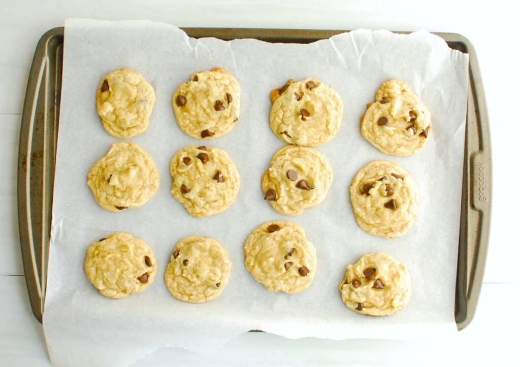 Just-baked cookies on a parchment-lined baking sheet.
