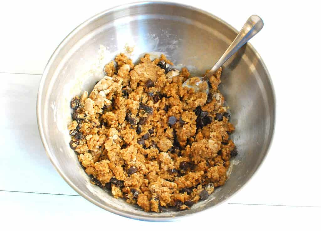 The cookie dough mixture in a silver mixing bowl.